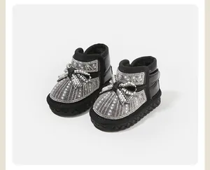 Detailed view of warm baby girl snow boots decorated with sparkling rhinestones and pearls