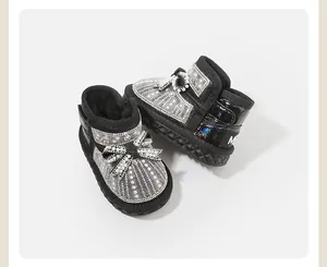 Detail shot of black baby girl snow boots with faux pearl and rhinestone bow