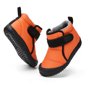 Detailed side view of orange children's winter snow boots with warm fleece lining
