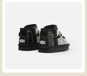 Close-up of black baby snow boots with rhinestone and pearl embellishments and MBX logo