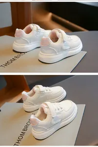 Detalle de zapatillas blancas cálidas para niños con forro de felpa y cierre de velcro.