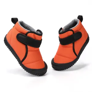Detailed view of vibrant orange children's winter snow boots with warm fleece lining