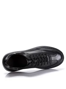 Top-down detail of black leather casual men's sneakers with thick platform soles