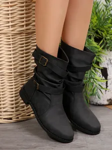 Close-up of black western mid-calf boots featuring stylish decorative buckle straps