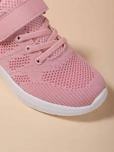 Close-up macro detail of pink breathable knit mesh material on girls' sports sneakers
