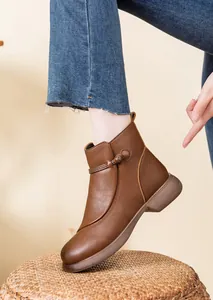 Close-up detail of brown leather ankle boot for women with vintage knot decoration