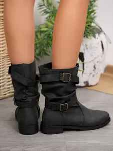 Side view of black mid-calf boots with buckle straps and slouchy leather texture