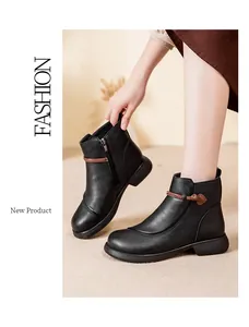 Detail view of black leather ankle boots with decorative brown cord and side zipper