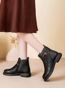 Close-up side view of black leather winter ankle boots with a cute heart knot detail