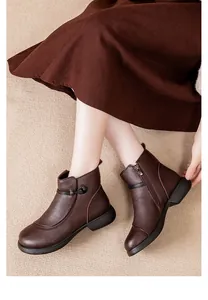 Close-up of warm dark brown leather ankle boots with side zipper and decorative knot