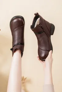 Detailed close-up view of warm brown leather ankle boots with thick faux fur lining