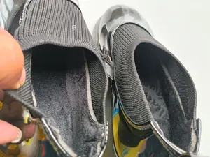 Interior detail of warm black fleece lining in girl's patent leather shoes for winter.