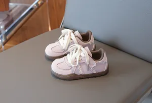 Nahaufnahme stylischer lila Kindersneaker mit Spitzenbesatz und weicher brauner Sohle