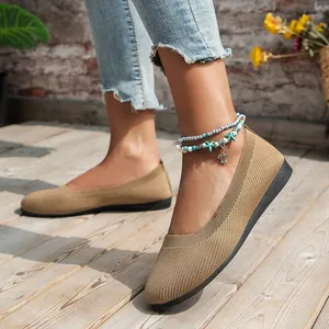 Close-up of comfortable tan knit ballet flats for women on a sunny wooden deck.