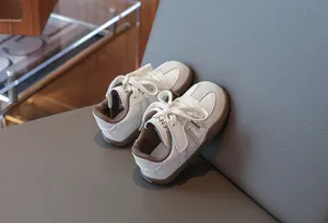 Detailansicht stilvoller weißer Kindersneaker mit weichen braunen Sohlen für Jungen