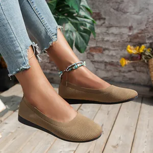 Close-up of khaki knitted round-toe flat shoes worn with casual denim and anklet.