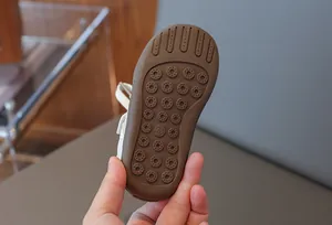 Nahaufnahme der braunen rutschfesten Gummisohle für Kinder-Sneaker in Größe 23
