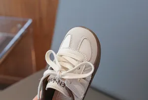 Detailansicht der Zehenpartie und Schnürsenkel weißer Kinder-Sneaker aus Leder mit weicher Sohle