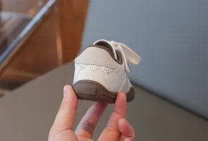 Detailansicht der weißen Kinder-Sneaker mit dekorativer Spitze an der Ferse hinten