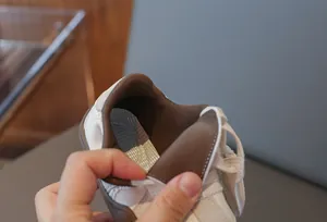 Detailaufnahme des atmungsaktiven braunen Netzfutters eines weißen Kinder-Sneakers