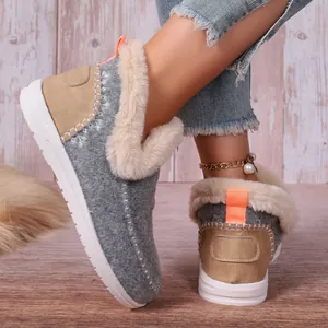 Gros plan de bottes de neige en feutre gris avec doublure en fausse fourrure crème.