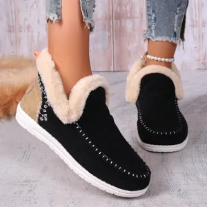 Gros plan de bottes de neige en daim noir pour femmes avec doublure en fausse fourrure blanche
