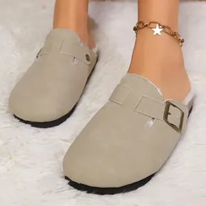 Detailansicht beige Wildleder-Clogs mit warmem Fellfutter und Schnallenriemen auf Teppich