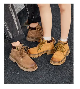 Detail view of couple wearing classic yellow leather Martin boots on asphalt background