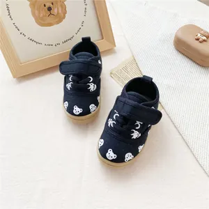 Close-up of children's navy canvas shoes with white bear patterns and Velcro straps