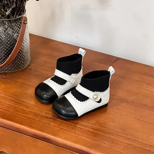 Macro view of baby girls' black and white knit short boots with decorative pearl buckle