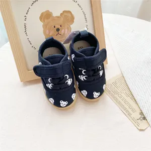 Detailed view of children's navy canvas shoes with cute white bear patterns and velcro