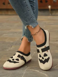 Close-up of Halloween pumpkin print fly-knit loafers with stylish buckle and anklet.