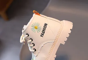 Detailansicht der weißen Kinder-Martin-Stiefel mit Gänseblümchen-Stickerei und Schnürung