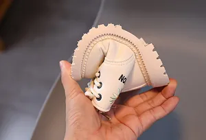 Detailansicht der flexiblen Sohle an cremefarbenen Martin-Boots für Kinder mit Blume
