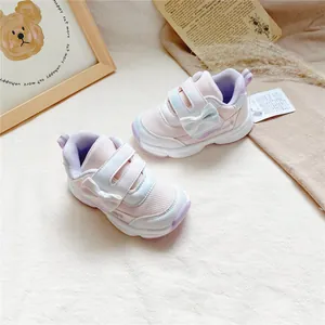 Vue détaillée des baskets roses en maille pour filles avec nœud blanc et scratchs