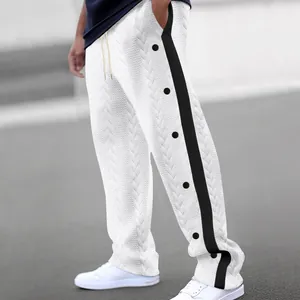 Vue détaillée du pantalon jacquard blanc pour hommes avec rayures latérales et boutons noirs.