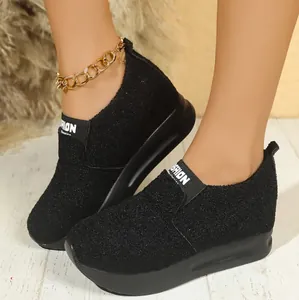 Gros plan de baskets à plateforme compensée noires respirantes au design slip-on.