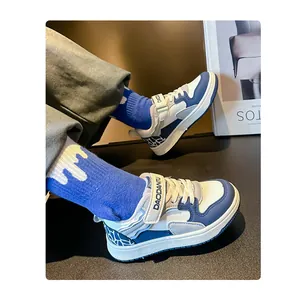 Vista detallada de las zapatillas azules y blancas para niños con correa de velcro DAODANTU