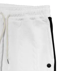 Gros plan d'un pantalon jacquard blanc pour homme montrant le tissu et la taille.