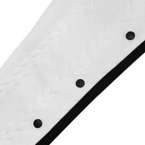 Gros plan sur un tissu jacquard blanc avec boutons noirs sur un pantalon homme