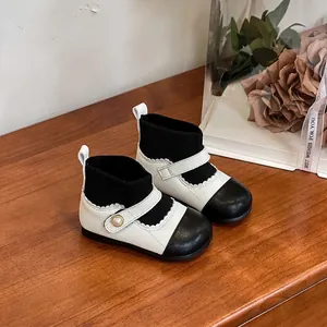 Elegant black and white baby girl winter boots with soft soles and pearl accent for walking.