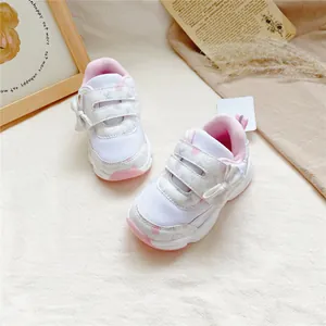 Vue détaillée de baskets blanches pour bébés filles avec nœuds roses et velcro