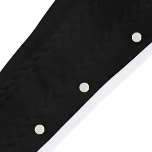 Gros plan sur le tissu jacquard noir et les boutons blancs d'un pantalon décontracté