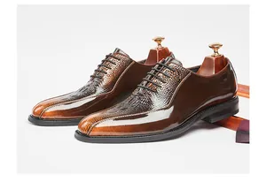 Brown glossy dress shoes with crocodile-embossed pattern and lace-up details