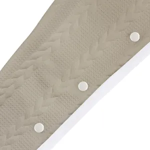 Détail en gros plan de la texture jacquard tressée et des boutons blancs sur un pantalon d'homme