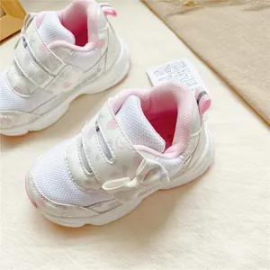 Gros plan de baskets rose et blanc pour petites filles avec nœud et bandes velcro