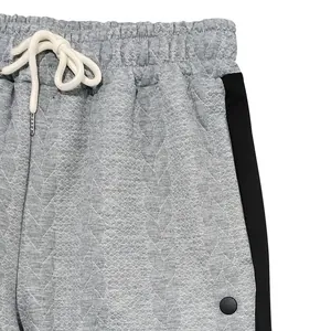 Vue détaillée du pantalon en jacquard gris avec bande latérale noire et cordon