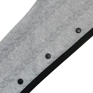Gros plan sur le tissu jacquard à motifs de feuilles et les boutons noirs du pantalon