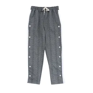 Vue détaillée d'un jogging en jacquard gris avec bandes blanches et boutons argentés