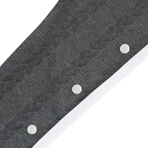 Détail de près d'un pantalon large en jacquard gris pour homme avec boutons blancs